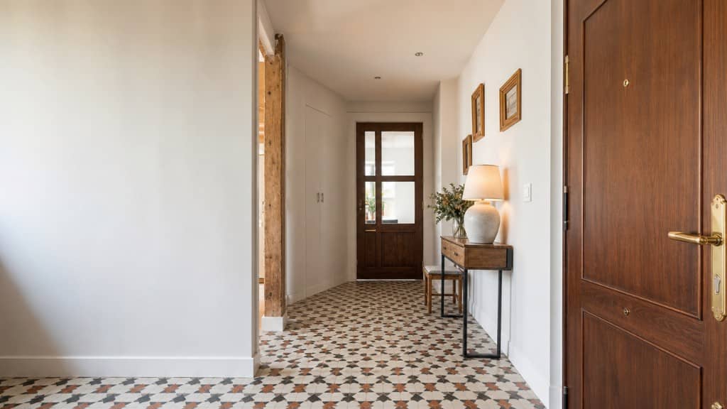 Entrada y recibidor de piso reformado con consola, espejo y madera