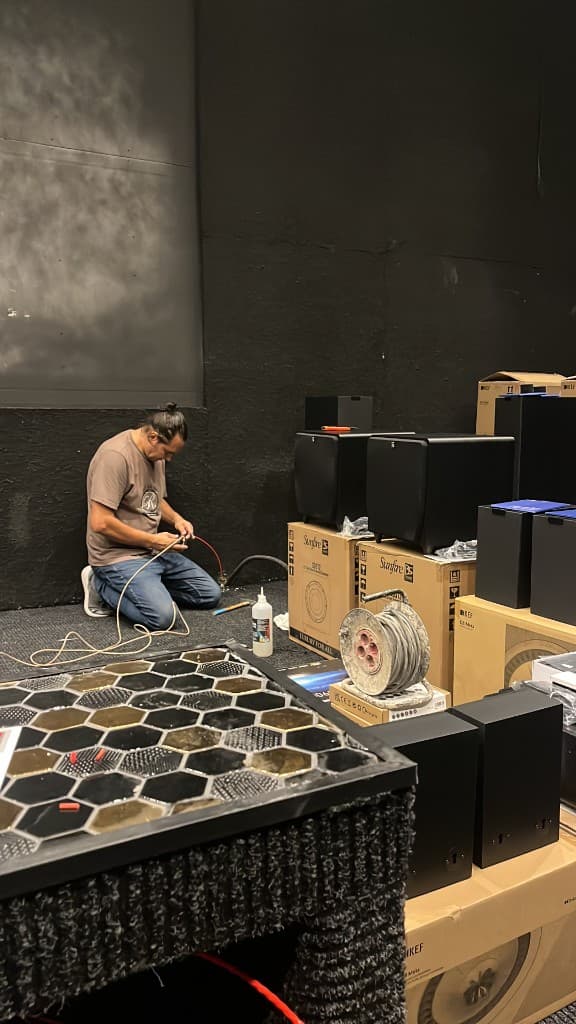 Instalador audiovisual conectando cableado en sala de cine en obra