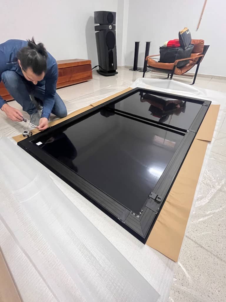 Profesional ensamblando pantalla de proyección en reforma de vivienda