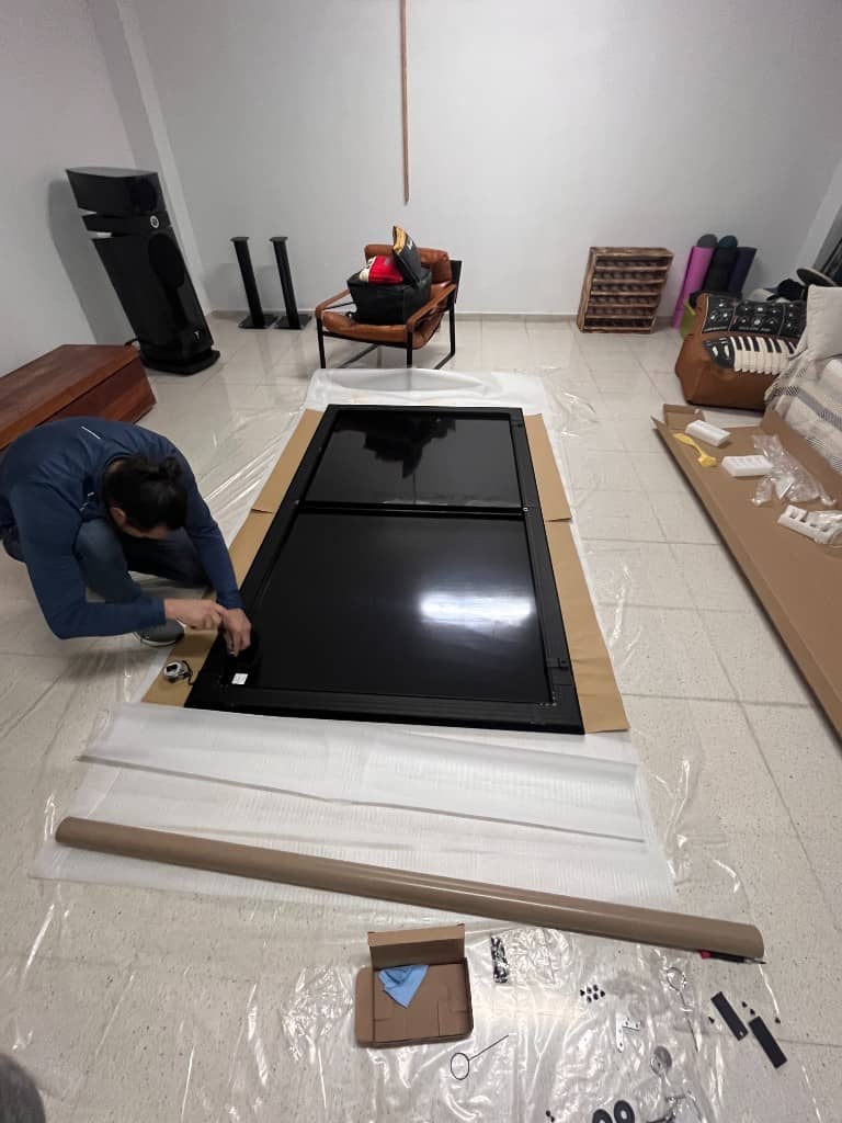 Instalador ensamblando el marco de una pantalla de cine en casa